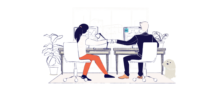 A man and a woman sit at a desk looking at computers, they are fist pumping
